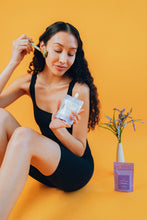 Load image into Gallery viewer, Model applying Ama Calma Lavender Infused Flaxseed Moisturizer