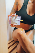 Load image into Gallery viewer, Model applying Ama Calma Lavender Infused Flaxseed Moisturizer