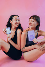 Load image into Gallery viewer, Models holding Terra Calma Lavender Clay Salt Scrub for Face and Body