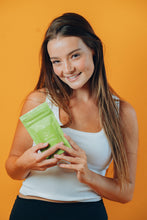 Load image into Gallery viewer, Model holding Terra Vida Matcha Clay Salt Exfoliant for Face and Body